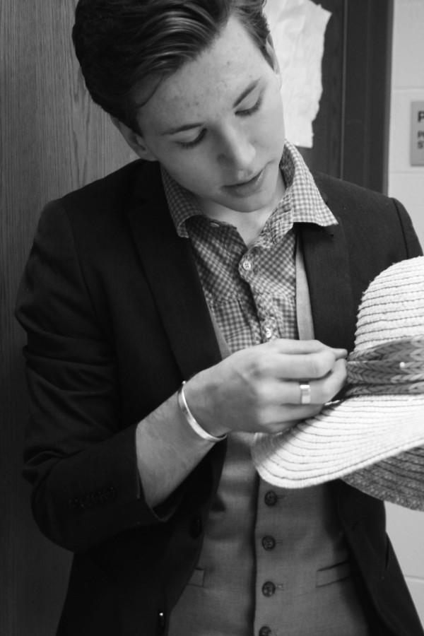 Patrick Broderick, senior and costumes co-captain, work to add a piece of fabric to a hat.