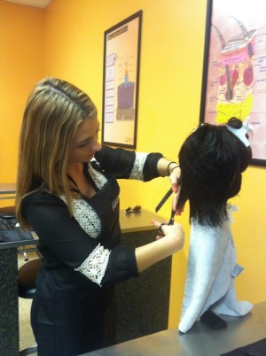 Vanessa Remblake, a winter 2014 graduate, styles a mannequin's hair at Empire Beauty School in Arlington Heights. Remblake aspires to craft wigs for cancer patients. She has already started to get involved by contacting an organization that provides wigs for cancer patients and by raising money for cancer research. 