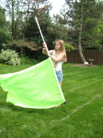Abby Smith, freshman, practices with her guard flag. She joined Color Guard with hopes to meet lots of new friends. Photo credits to Abby Smith. 