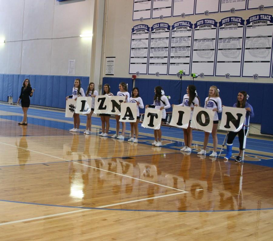 The Varsity Cheer team holds the new school hashtag. This year, Student Council is trying to unite the school by creating a school wide hashtag. 