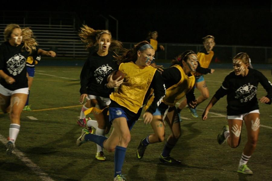 Junior+and+senior+girls+playing+on+their+powder+puff+team+in+2013.++The+Varsity+Football+players+coach+the+female+athletes.