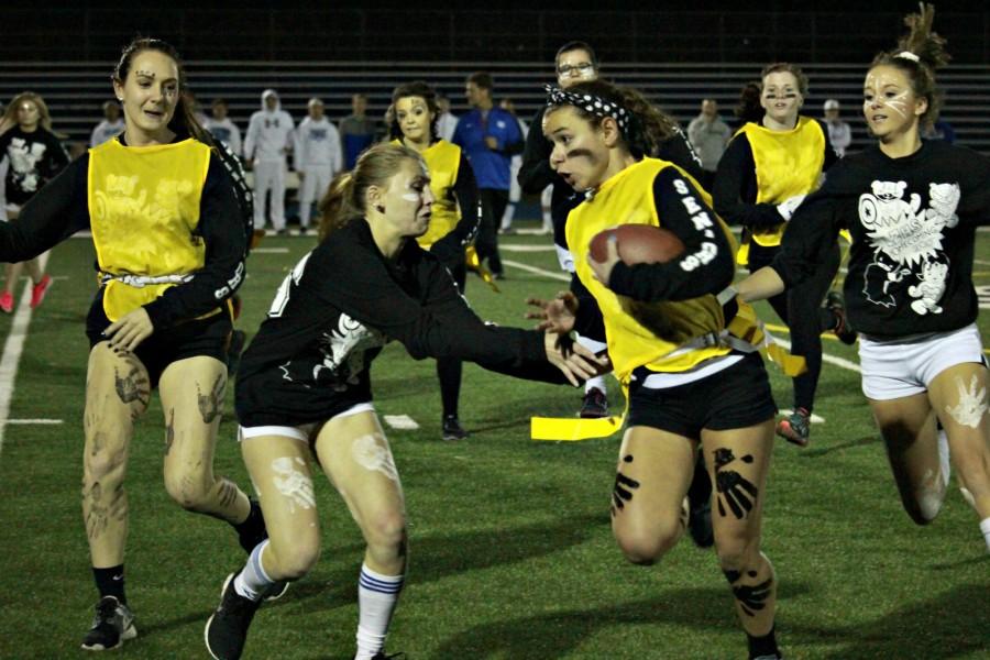 Vanessa DiVincenzo, senior running back, cuts up the sideline while dodging tackles. She went on to score 4 touchdowns and an extra point to lead the black team to victory.