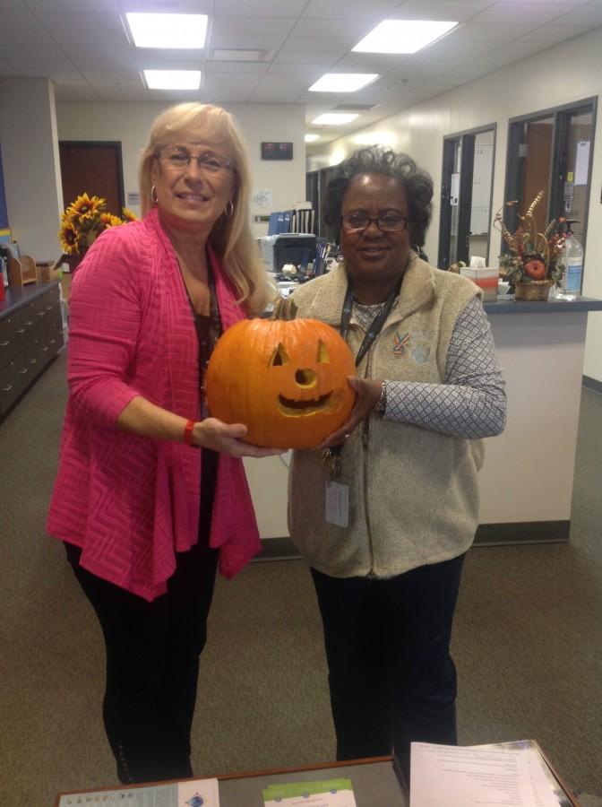 Helen Rzasa and Pollie Greenhalgh hold the jack o lantern gifted to the school by the Alexander Leigh Center.