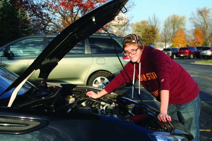 Mike Young, senior, works on his car to practice his skills as a car mechanic. Young is one of many who have decided to graduate early, and is planning to use this time to work.