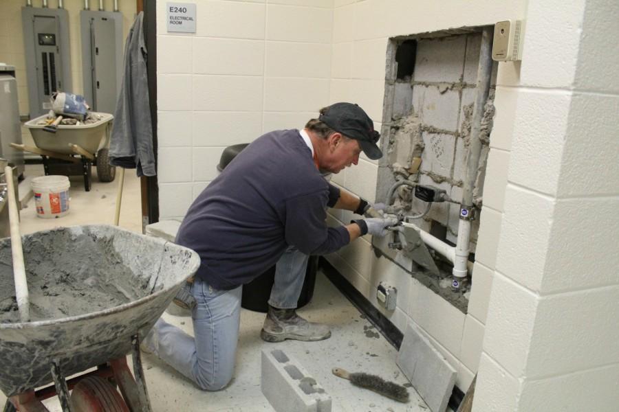 A mason lays the stone which will go behind one of the new watering stations. The school is replacing about a half dozen water fountains with watering stations to make sure lead doesnt build up from infrequent use and keep other fountains safe.