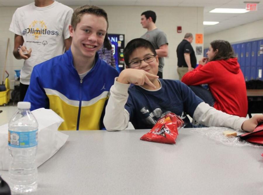 Brett Hensely, junior, sits with David Bae, sophomore, during sixth period lunch as part of the Lunch Buddies program. The program was started to integrate Life Skills students with athletes.  Photo by Jemma Kim