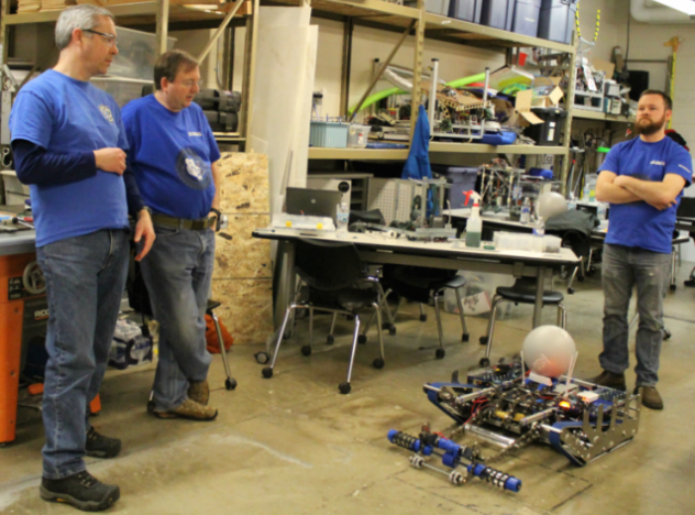 Robotics team mentors oversee the  testing of their robot, Smokey IX. The robotics team will be demonstrating their robot at the science fair on Saturday.