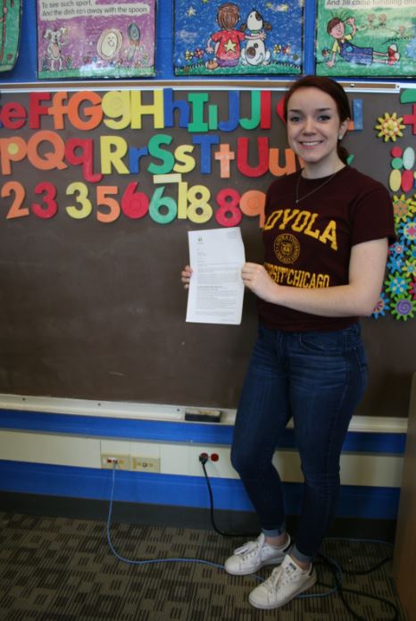 Caroline Niepsuj, senior stands in the Child Development room holding her Golden Apple Scholarship letter. Niepsuj received a scholarship to attend the University of Loyola next fall. 
