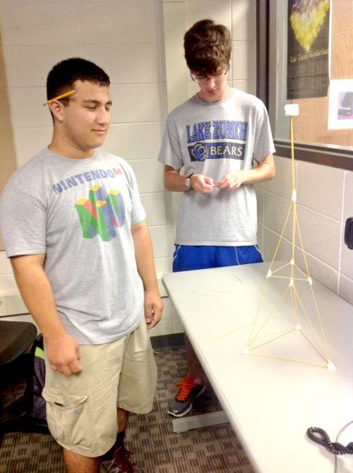 Andy Gatza, freshman, and John Burke, senior, finish a tower their group made out of spaghetti, tape, and a marshmallow. This exercise on the first day of class was designed to promote problem solving and creativity, according to Ann Heltzel, computer science teacher.