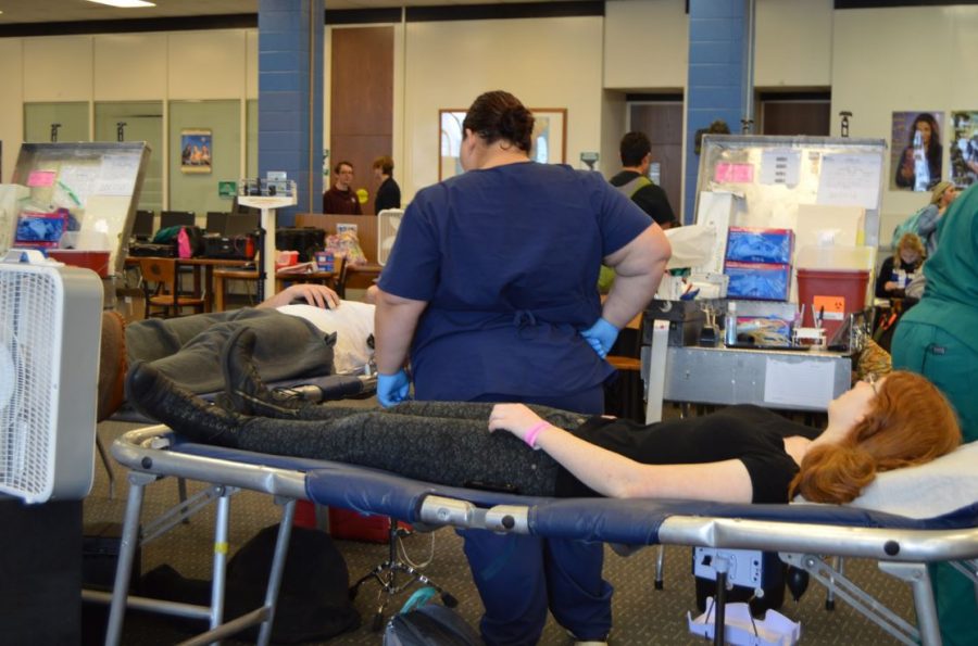 Students lie down while donating blood in the school library. The blood drive will be held on October 27. 