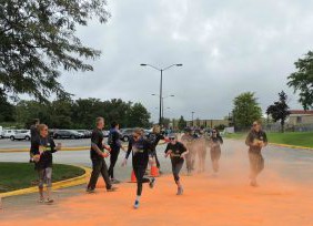 Runners are splashed with orange as they make their way to the halfway point at May Whitney.