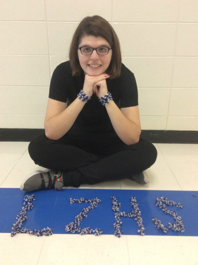 Emily Nelson, transition student, sits with her rainbow loom bracelets.  Nelson makes bracelets for athletes on the football, basketball, and baseball teams. 