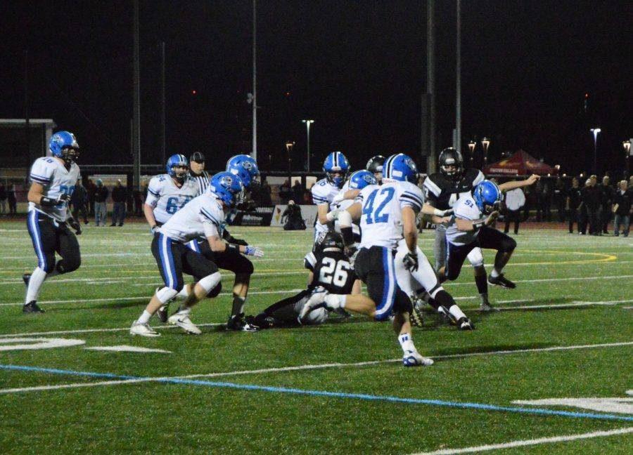 Football players run a play during the November 5 playoff game against Fenwick, a week after alleged hazing took place in the locker room. In response to that incident, administration has reiterated rules on student supervision to faculty and the student body. 