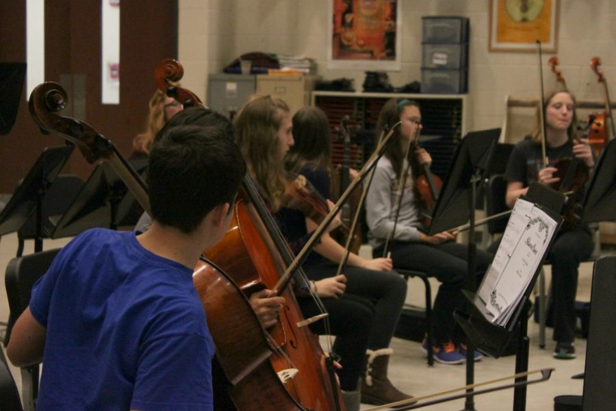 Orchestra students prepare for their holiday concert. With the help of Nathan Sackschewsky, the new orchestra teacher, the students are learning to incorporate band students into their music. 