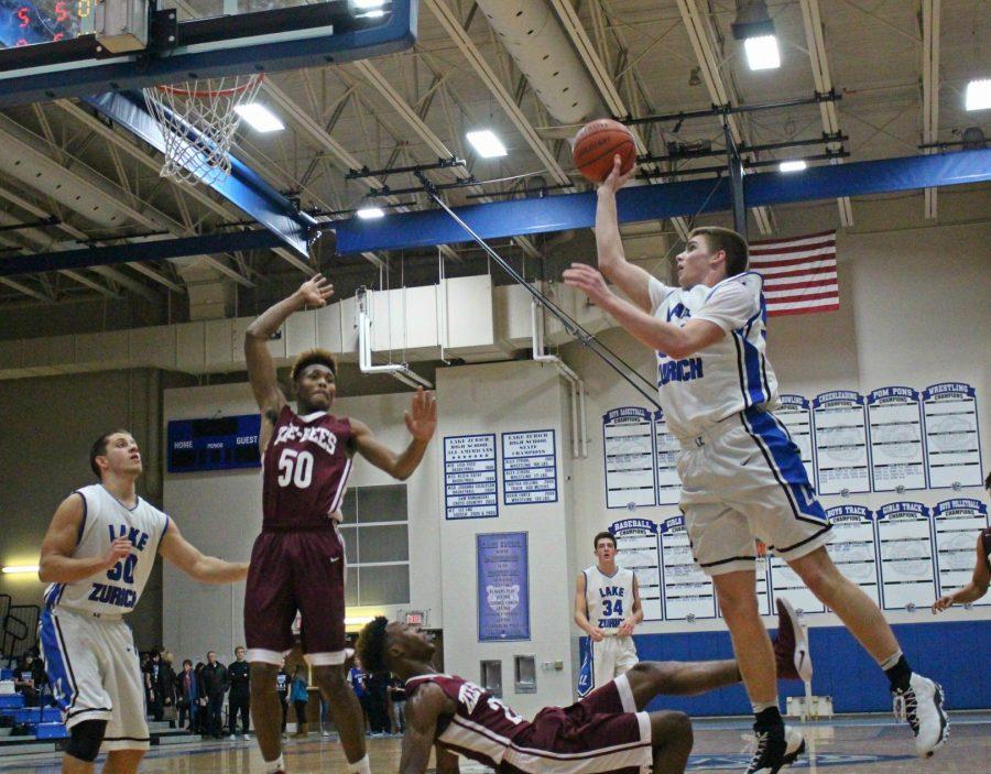 Peter DiCerbo, junior power forward, leaps up for a layup against a Zion Benton defender during Pack the Place.