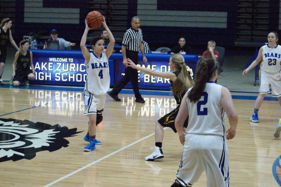 Eleni Papastratakos, junior basketball player, looks for a pass in the November 23 game against Fremd. Papastratakos believes that the gender inequality in attendance at high school sporting events can be corrected.