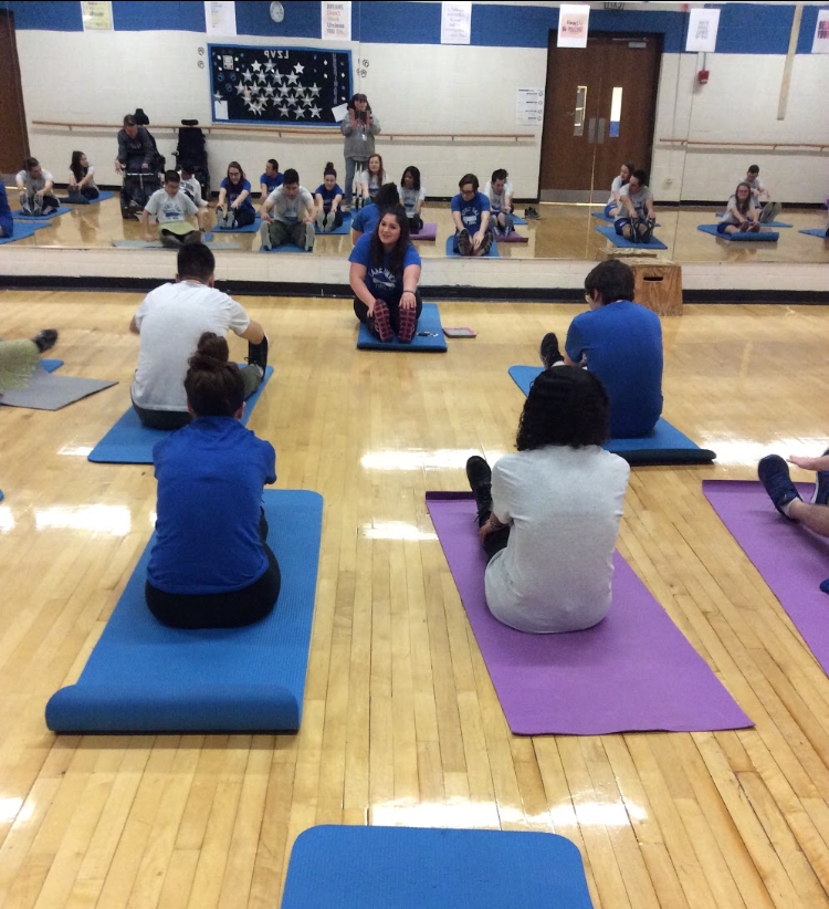 Sydney Shadrick, senior, leads the integrated PE class through a yoga workout. Shadrick intends to continue working with people with disabilities throughout her life.