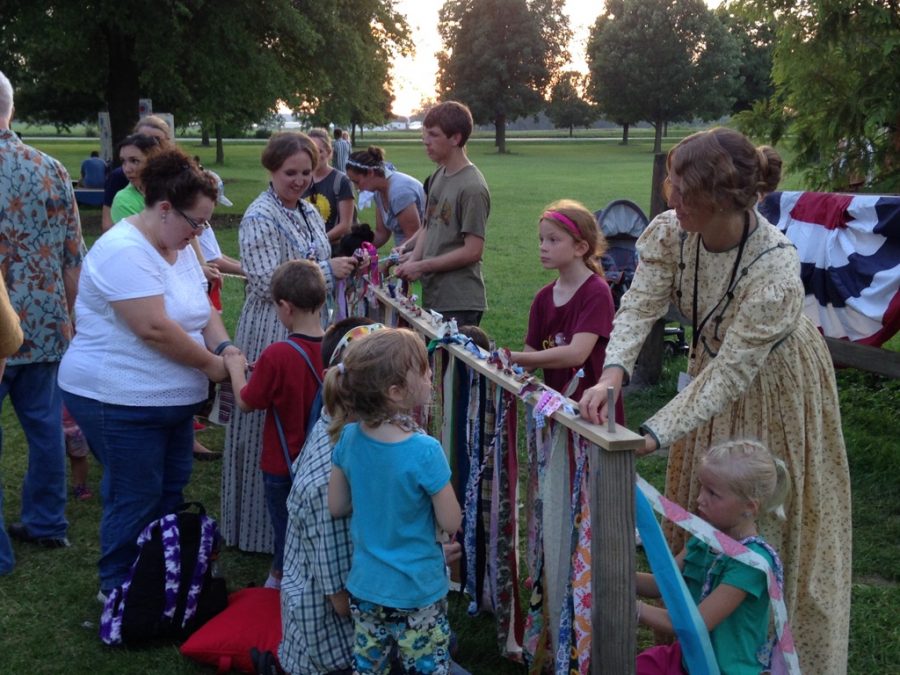 Children participating in the Nauvoo fair weave the rag ties, one of the toys Nathan Holbrook, junior, is making for his Eagle Scout project. 