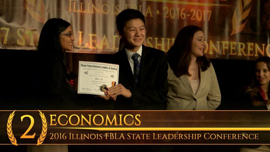 Alex Li, senior, stands with his medal and certificate for his second place win in Economics.