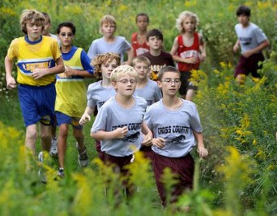 Seniors Patrick True (left) and Patrick Burns (right) shown here in a middle school cross country race, will be considered 12 sport athletes by the time they graduate after participating in three sports each of their four years throughout high school. Although the boys agree that being a part of the cross country, swim, and track teams is a time commitment, the two have no regrets and say it is all worth it. 