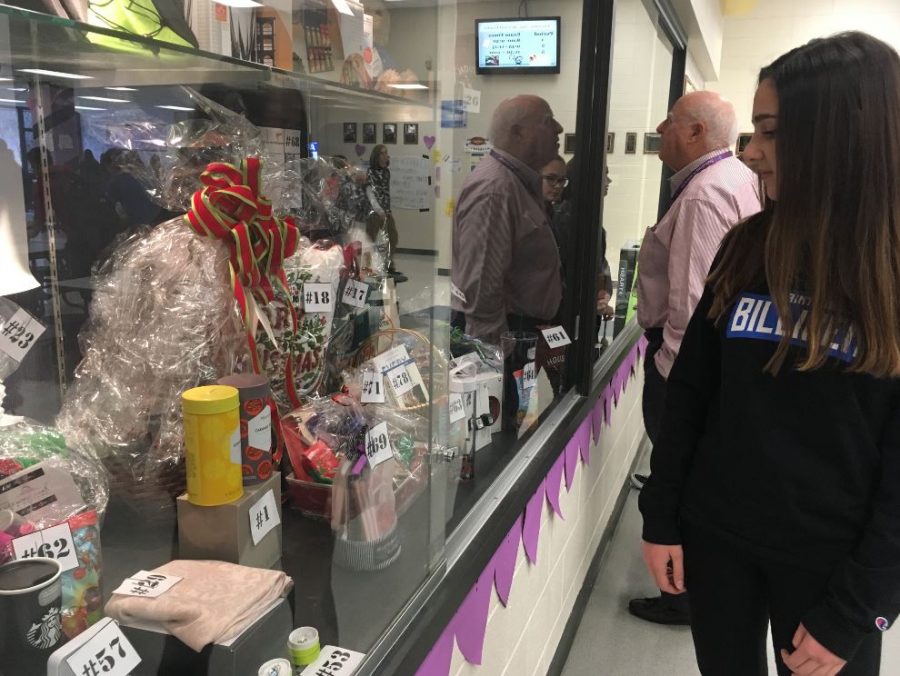 Jillian Castellani, sophomore, checks out items available to bid on at the auction wall. Student Council is running the auction wall to raise money for charity bash.