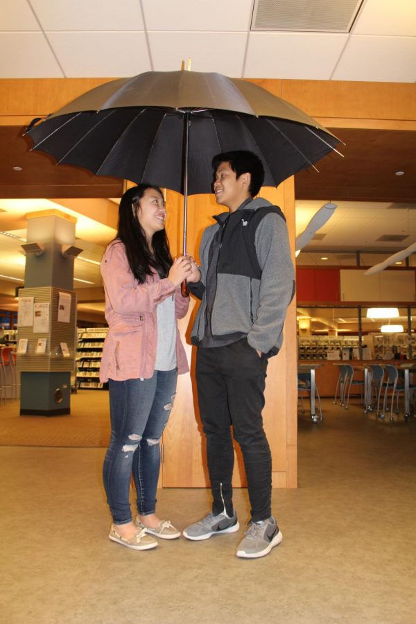 Matt Mauleon and Nicole Savage, senior couple, stands under an umbrella. Dating for over three years, the couple has battled the element of time throughout their long relationship.