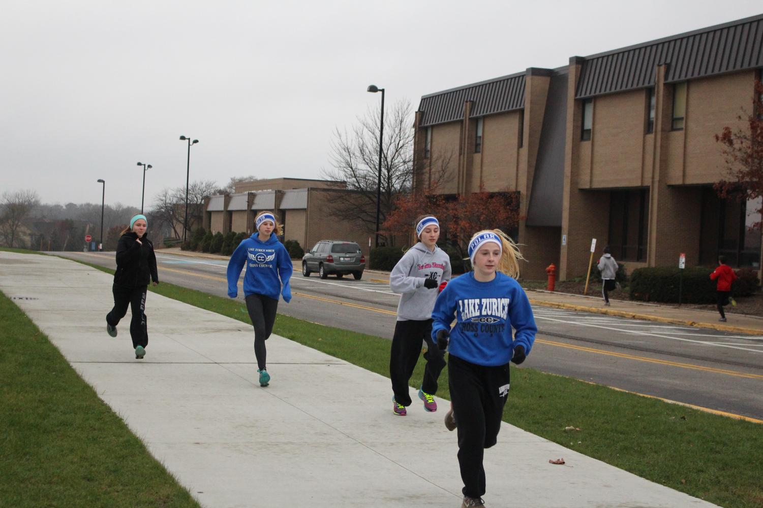 Hayley Burk, freshman, Emily Burns and Jillian Baffa, juniors, running after school for Polar Bears. Members of Polar Bears meet daily after school to train in the offseason.
