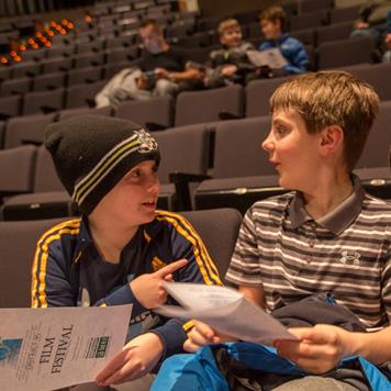 Students hold film festival pamphlets while waiting for the viewing and awards to start from a perviously held festival. The festival is in its sixth year and will take submissions until January 26 to be featured on February 13 in the PAC.