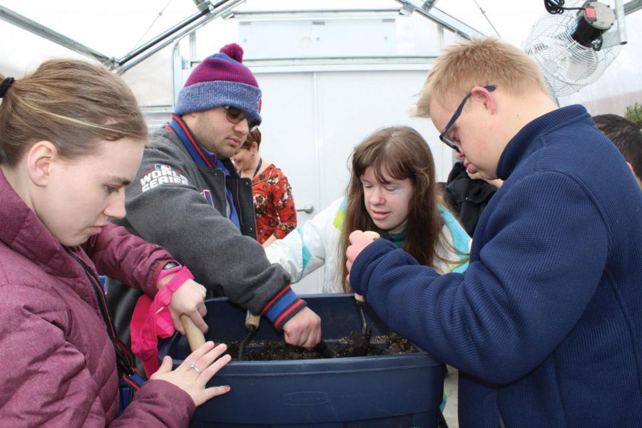 Transition students add water to the soil in the greenhouse. Now that spring is near, activity in the greenhouse will pick up for students.