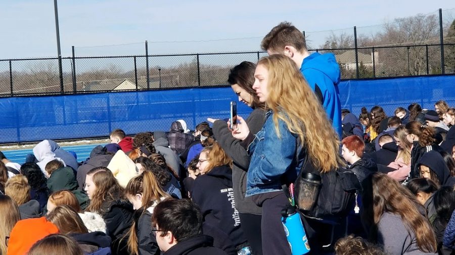 Julia Funk, senior, stands with other seniors among the sea of the students attending the walkout on March 14. At the school sanctioned, non political event, Funk and others passed out Our Opinions Matter, and Enough is Enough, signs to some students. Some people questioned if the signs fit the nonpolitical nature of the event.