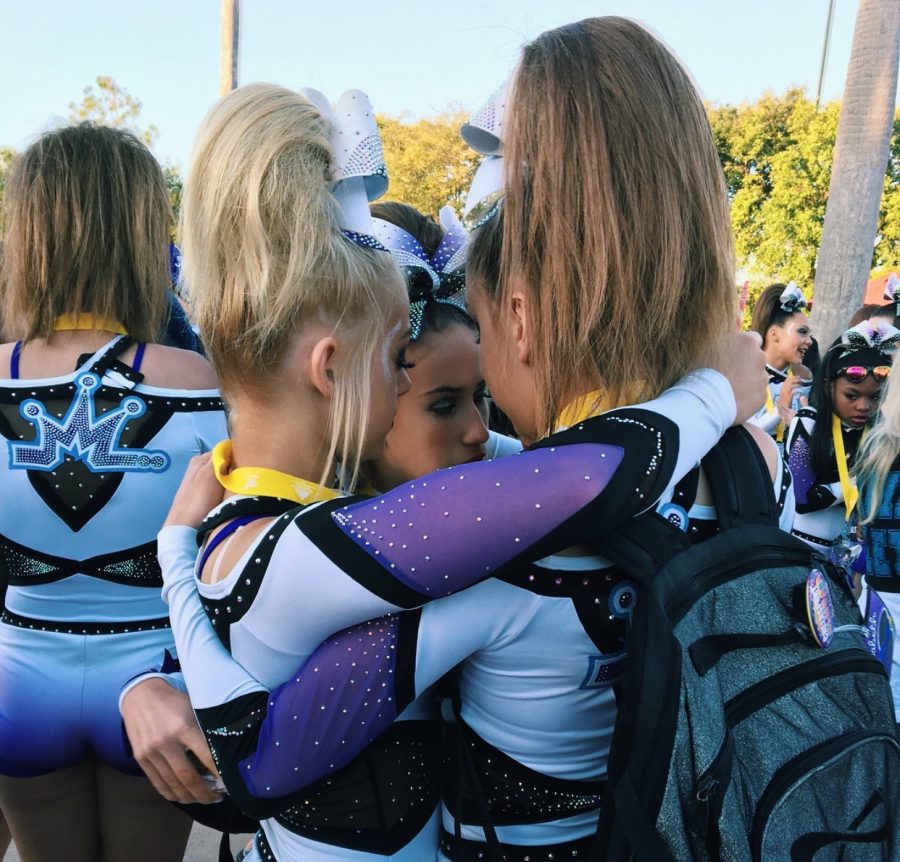 Elizabeth Russis, freshman, and her teammates share a hug after a successful competition. Teammates can offer different experiences as well, dynamics between girls on compeitive and highschool cheer can offer different experiences for cheerleaders.