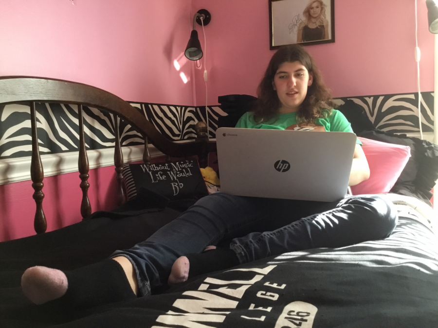 Senior Amy Cooper is shown on her chrome-book. Shes laying on her bed and writing her novels away.