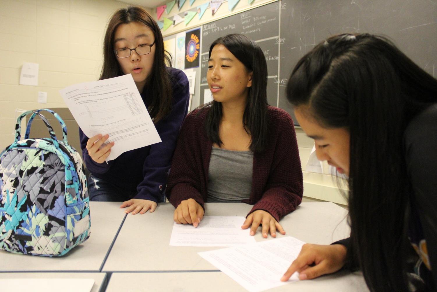 Sophomores Rachael Lee and Elizabeth Yen discuss their quiz corrections with Elizabeth's sister, Tiffany Yen. 5 underclassmen take AP Stats this year, breaking the norm, as it is a class typically taken by upperclassmen.