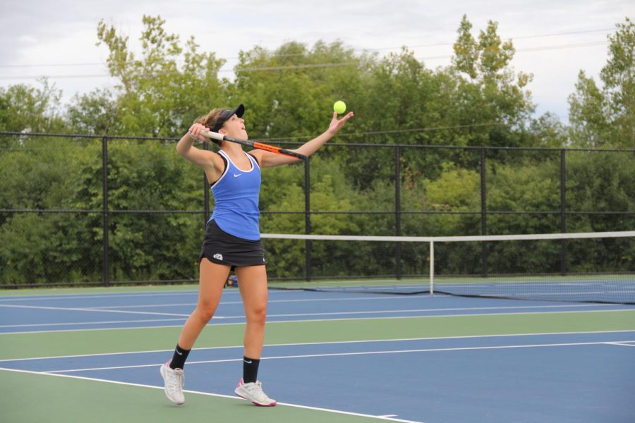 A Girls Tennis player prepares to serve. Although the team did not win many awards this season, Olivia Hughes, junior,  says that it was a good learning experience for the team.