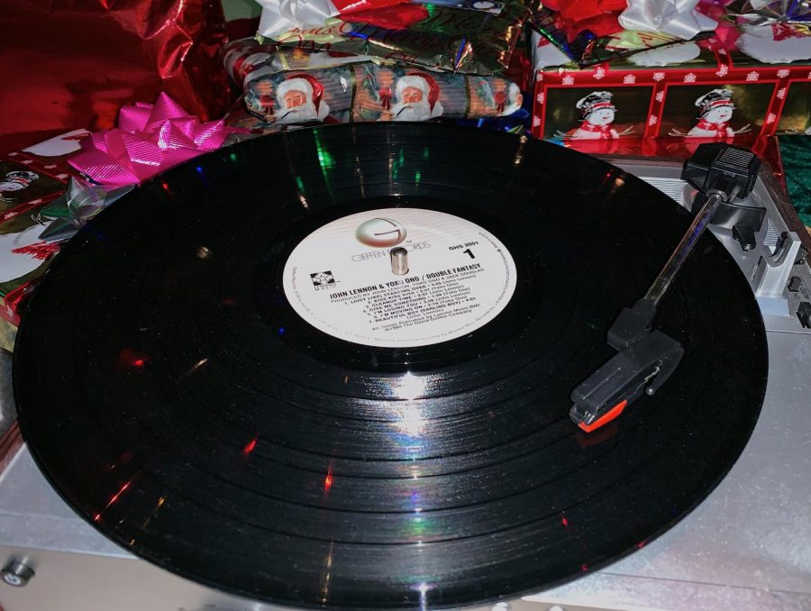 A+record+player+spins+a+vinyl+in+front+of+Christmas+presents.+With+these+top+5+Christmas+songs%2C+any+holiday+occasion+will+feel+special.