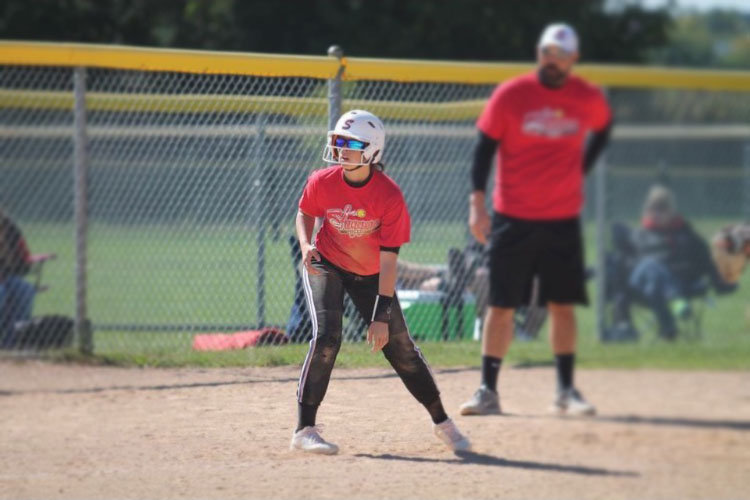 Waiting for the ball to be played, Kennedy Williams, who does club and school softball, sits on base. Her passion for softball has made her dedicated to the sport, deciding to do a club sport helps her gain experience and do what she loves. 