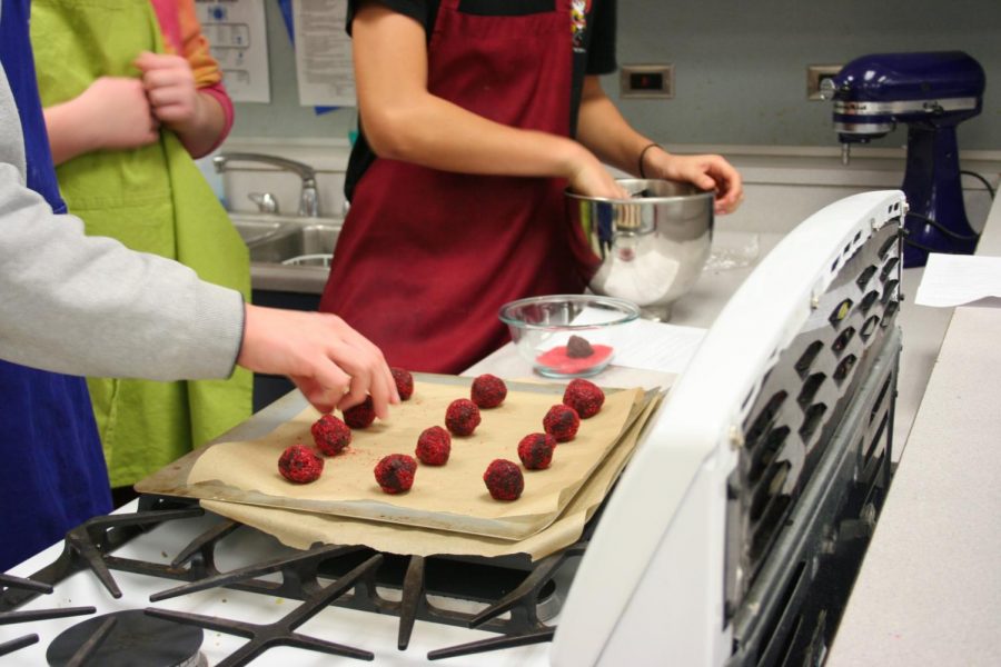 Students in the Period 1 Foods 1 class dip cookies into sprinkles before placing them into the oven. The classes teach you life skills. You learn about budgeting, how to prepare food, live a healthy lifestyle and how to live on your own. Student should take it so they can learn valuable life skills that they will need as adults Racheal Fischer, FACS teacher, said.