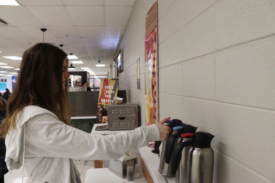 Rory OSullivan, sophomore, takes some cream for her coffee. With a wide variety of drinks to chose from, students say they find that even traditional coffee can be customized the way they like it.