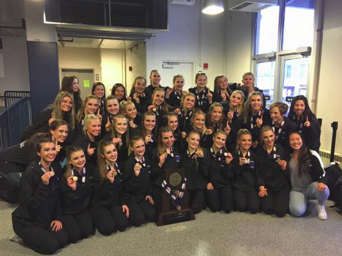 The team poses with the state championship trophy at Grossinger Motors Arena in Bloomington on January 26. This championship is the second consecutive state title for the team, and the second one in school history.