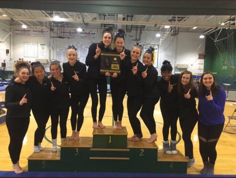 The gymnastics team poses with their Regional Championship hardware at Fremd High School on January 31. This victory ended Fremds 26 year Regional Championship streak