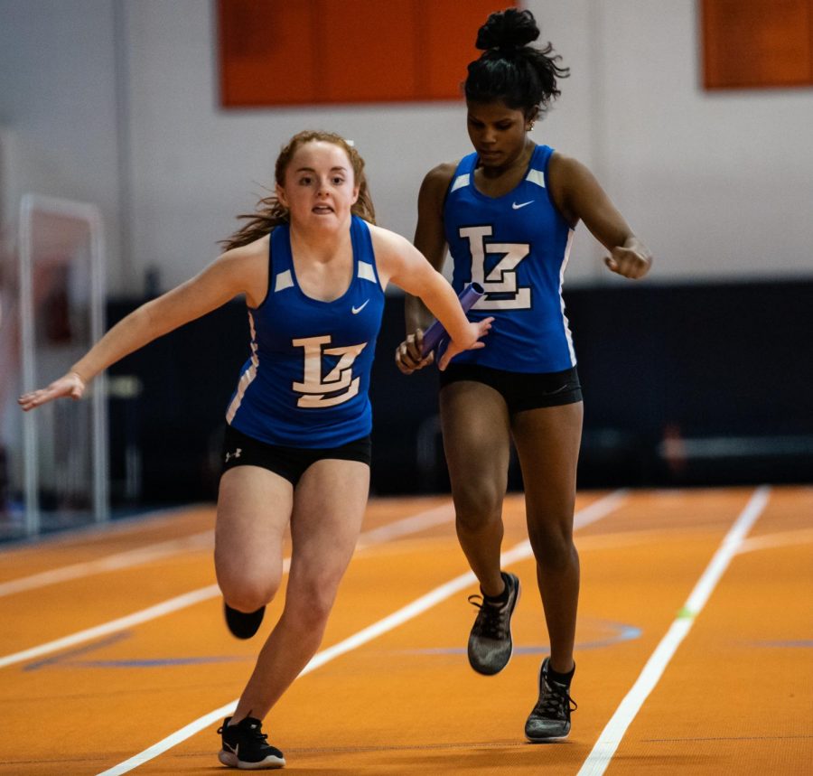 Rayna Kauffman, freshman, passes the baton to Cate Cillessen, freshman, in the Buffalo Grove Dual meet on Friday. The meet ended in a disappointing loss, but it was an improvement upon last year's score in the same meet