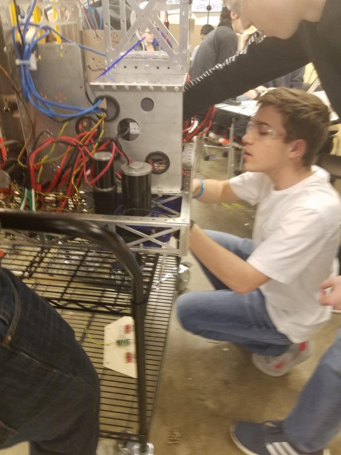 John McConnell, sophmore, is putting the finishing touches on the robot. Their upcoming competition is later next week.