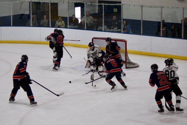 The hockey team attempts to deflect the puck away from their own net in a March 3 game against Wheaton. The game ended in a 5-0 loss, ending their season.