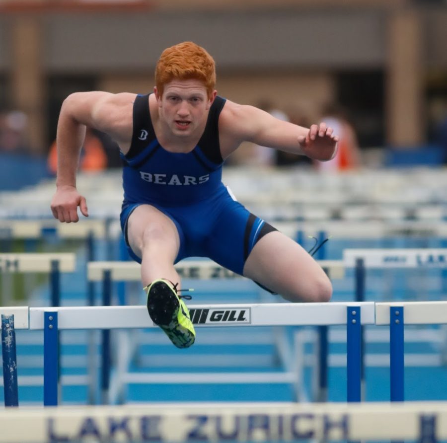 Marek Enters, senior, dashes over the hurdle in the 300 meter hurdles at the Bear Invite on Thursday. Enters came in third in the event.