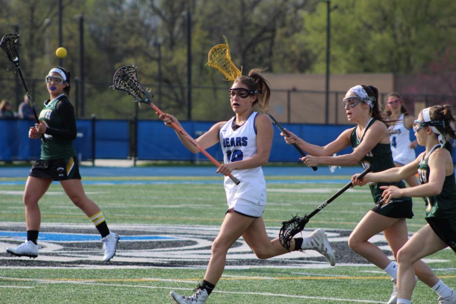 Emilia Mangiardi, sophomore, passes the pall down field in a game earlier this year against Glenbrook North. The team will be heading into Sectionals this week