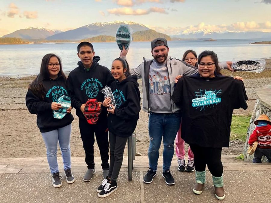 Jordan Addison, new English teacher, stands with his students in Alaska. His students wear their school spirit in form of t-shirts and hoodies as he supports the team.