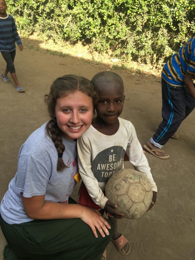Maya Wiley, senior, smiles with one of the kids from Africa, after playing soccer. Wiley not only played with the kids, but she also helped improve their schools.