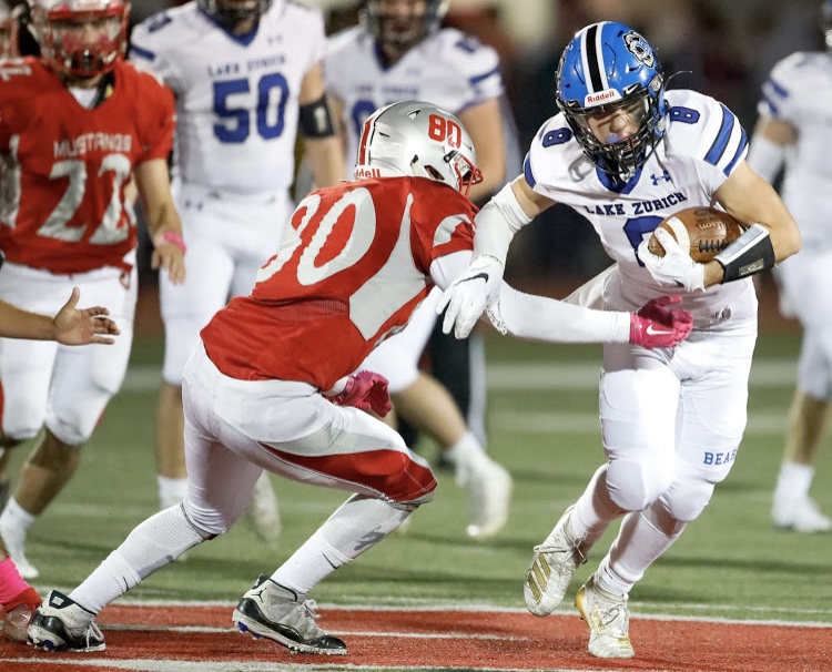 An LZ football player shields the ball against Mundelein at the game on October 18. Key touchdowns were made by Thomas Vages, Hunter Welcing, Collin Callahan, and Jack Moses.