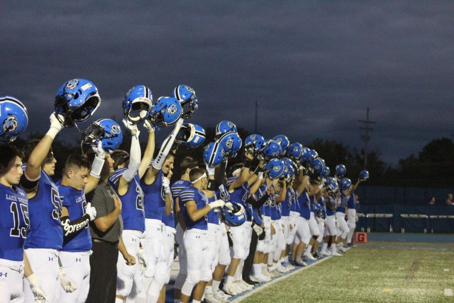 To kick off the start of the game, the football players lift their helmets ready to win against Marist.