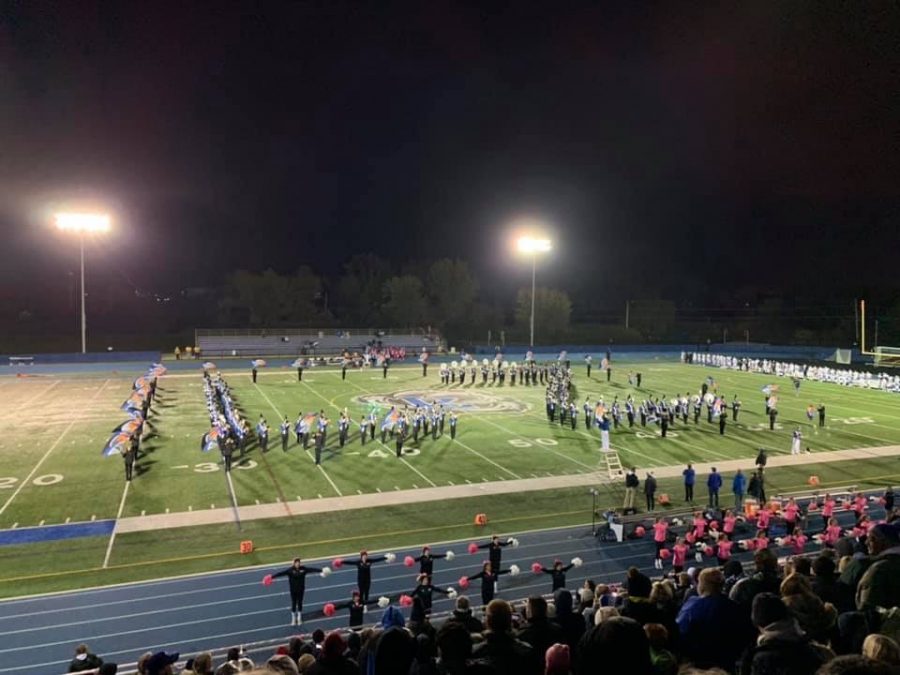 The marching band and color guard perform their halftime show at the football game.